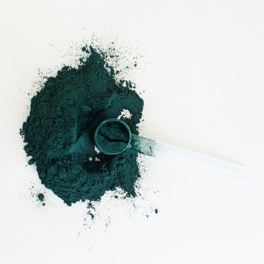 uma colher transparente com pó de spirulina