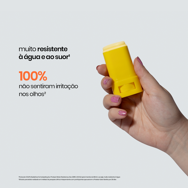 Mão segurando o Protetor Solar Bastão da Sallve sem tampa, com texto indicando que o produto é muito resistente à água e ao suor e não causa irritação nos olhos.